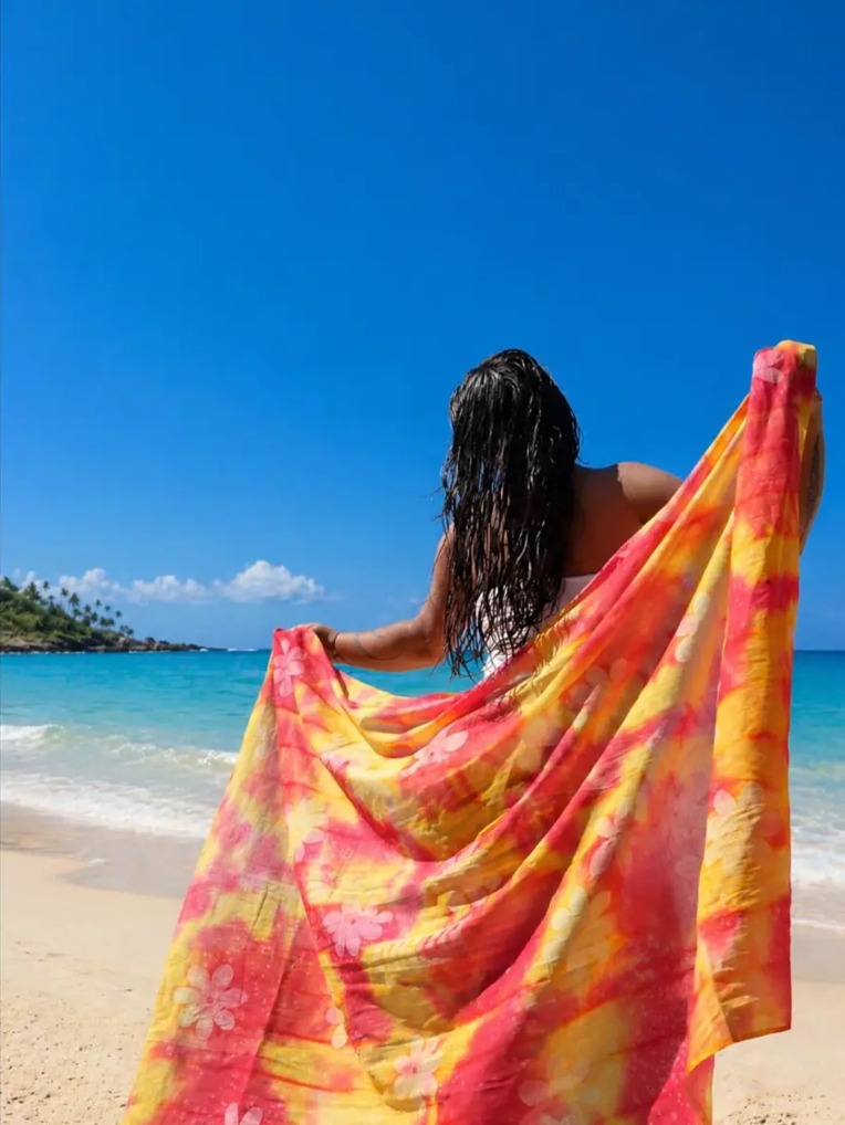 Portrait de dos sur une plage avec un paréo coloré du Fenua